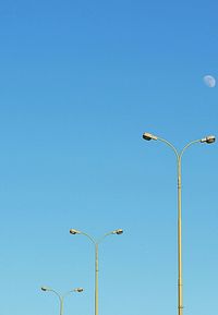 Low angle view of lamp post against clear blue sky