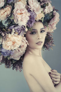 Portrait of woman with pink flowers against white background