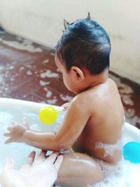 Midsection of shirtless man with toy in bathroom