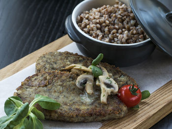 Close-up of mushroom burger with buckwheat porridge on table