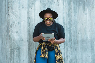 Young woman standing against wall