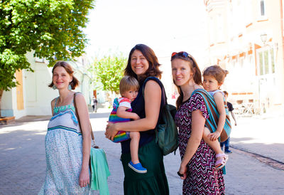 Portrait of smiling young women standing in city