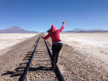 Woman standing on landscape against clear sky