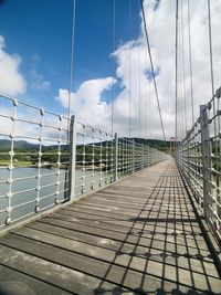 Empty footbridge against sky