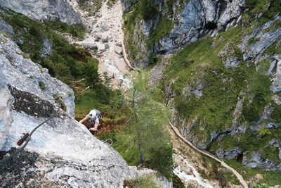 High angle view of woman climbing on rock