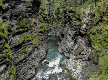 High angle view of stream amidst rock formations in forest