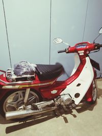 Close-up of motor scooter on street against wall