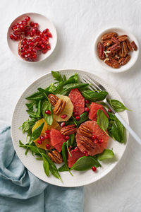 Top view of fruits citrus salad with nuts, green lettuce leaves. balanced food. spinach with orange