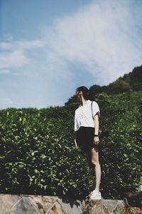 Woman standing on field against sky