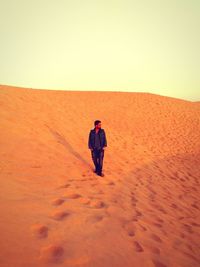 Full length of man standing at desert against sky