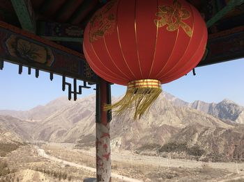 Red lanterns hanging on mountain against sky