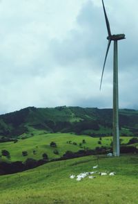 Windmill on field against sky