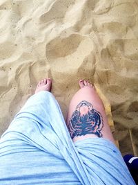 Low section of man standing on beach