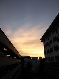 Silhouette bridge in city against sky during sunset