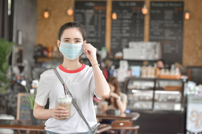 Portrait of mid adult man holding ice cream in city