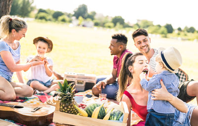 Family enjoying picnic in park against sky