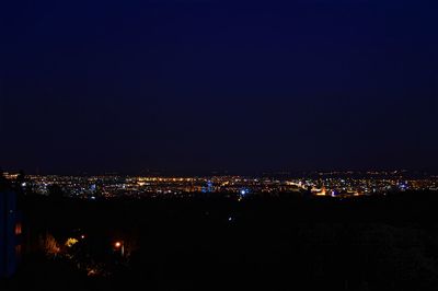 Illuminated cityscape against sky at night