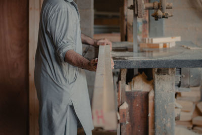 Midsection of man working at workshop