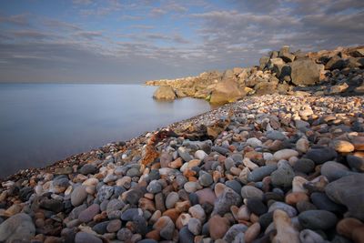 Pebbles on beach against sky