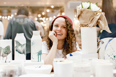 Charming woman among clay artisan utensil