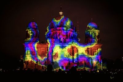 Illuminated traditional building against sky at night