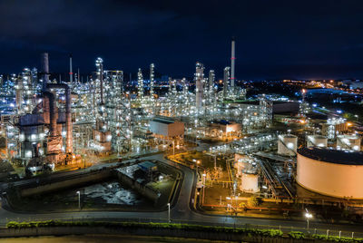 High angle view of illuminated city against sky at night