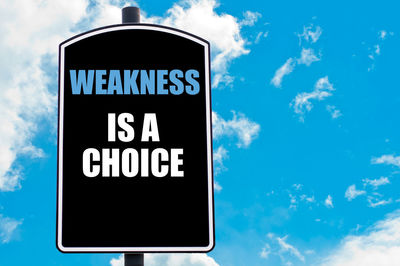 Low angle view of road sign against blue sky