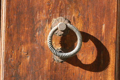 Close-up of door handle on wooden surface