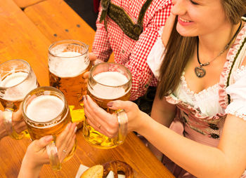 Close-up of woman holding beer glass on table