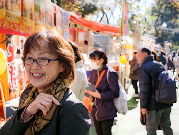 An older japanese woman smiling at a festival