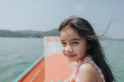Portrait of smiling woman against sea