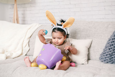 Portrait of cute girl with teddy bear on bed at home