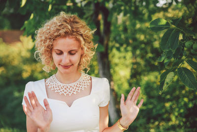 Close-up of smiling woman against trees