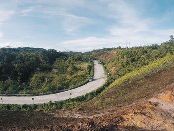 Scenic view of road by trees against sky