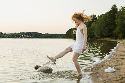 Happy woman splashing water at beach