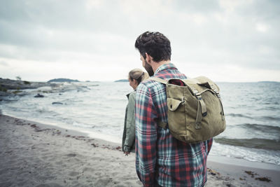 Side view of wonderlust couple walking on beach