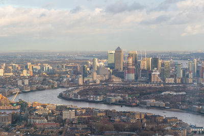 Aerial view of city by river against sky