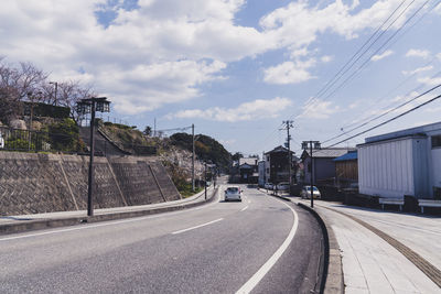 Road by city against sky