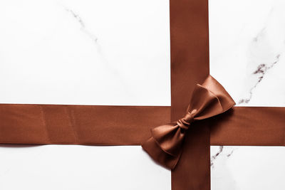 Close-up of ribbon tied on white background
