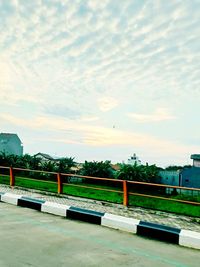 Empty road by buildings against sky