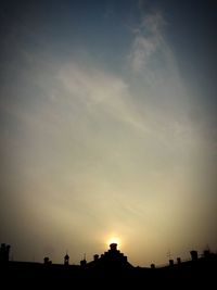 Low angle view of silhouette built structures against sky at sunset