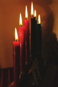 Close-up of burning candles in darkroom