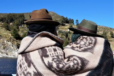 Rear view of friends wearing blanket against mountains