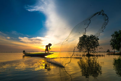 Silhouette fisherman catching fish