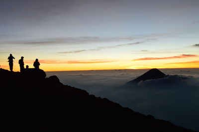 Silhouette of people on mountain during sunset