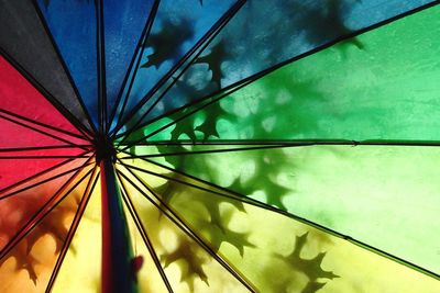 Low angle view of multi colored umbrella against blue sky