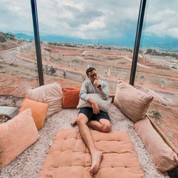 Man sitting on sofa against sky