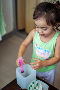 Child injecting organic fertilizer into small containers. fine motor skills activities for kids.