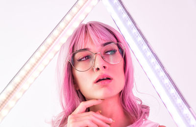 Close-up of beautiful young woman with pink hair looking away