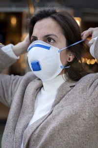 Close-up of woman wearing mask standing outdoors